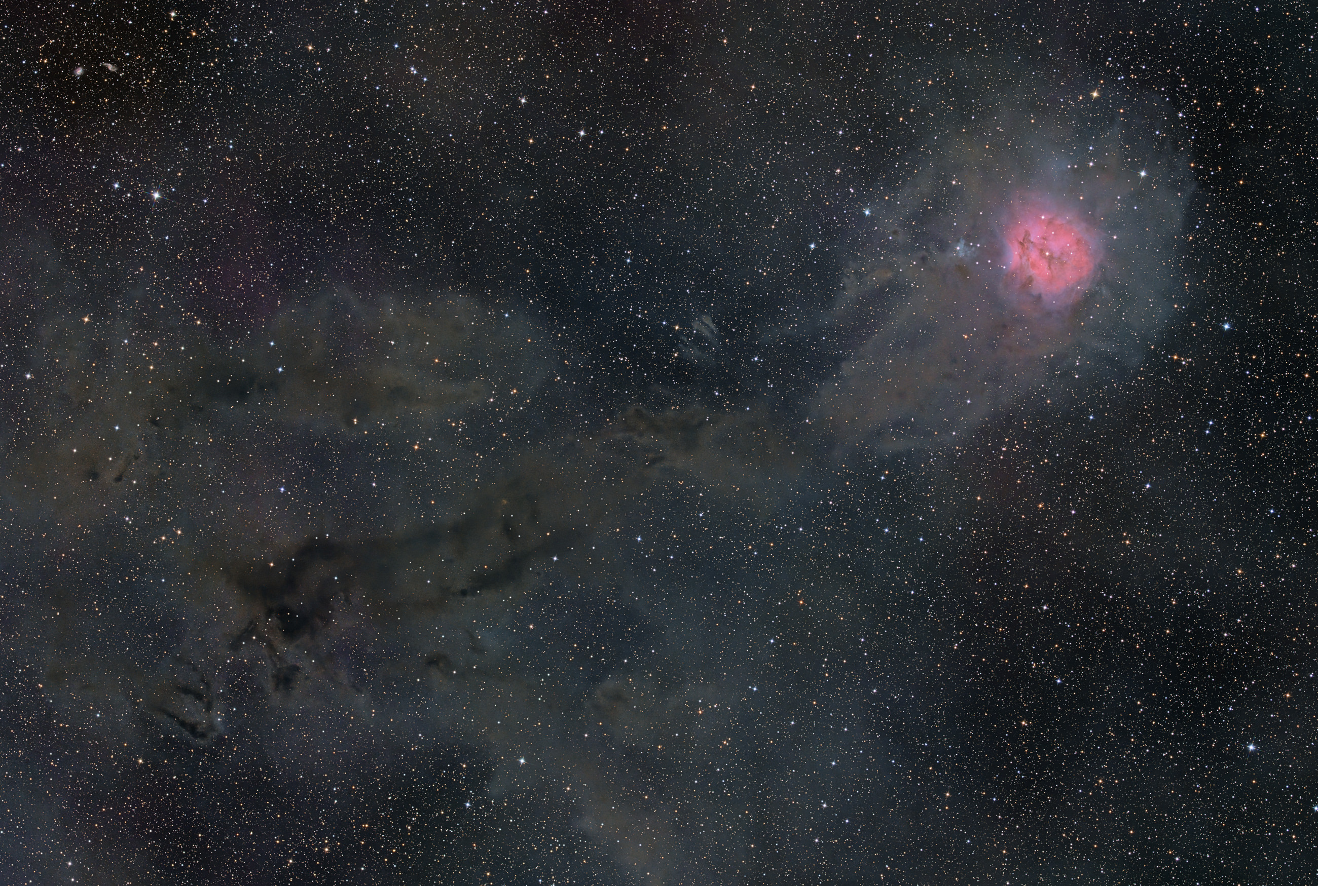 The Cocoon Nebula IC 5146, upper right, is a star-forming region with the embedded open star cluster Collinder 470 in the constellation Cygnus. IC 5146 is located at the end of the elongated dark cloud Barnard 168 and, together with it, is part of an extensive dust cloud.